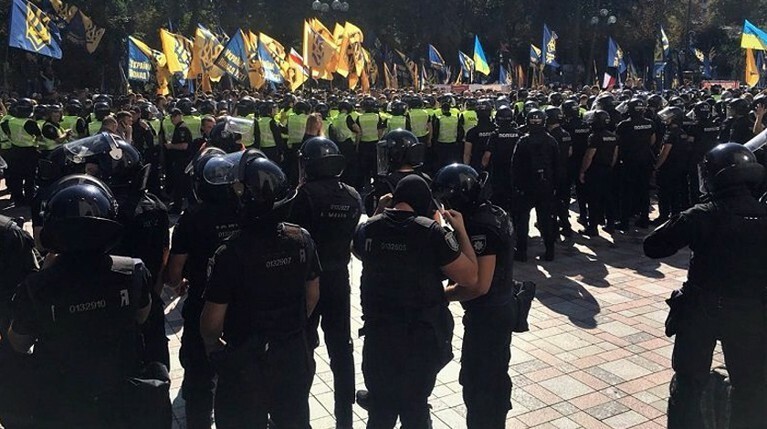 Митингующие начали забрасывать правоохранителей дымовыми шашками, как минимум один полицейский был ранен