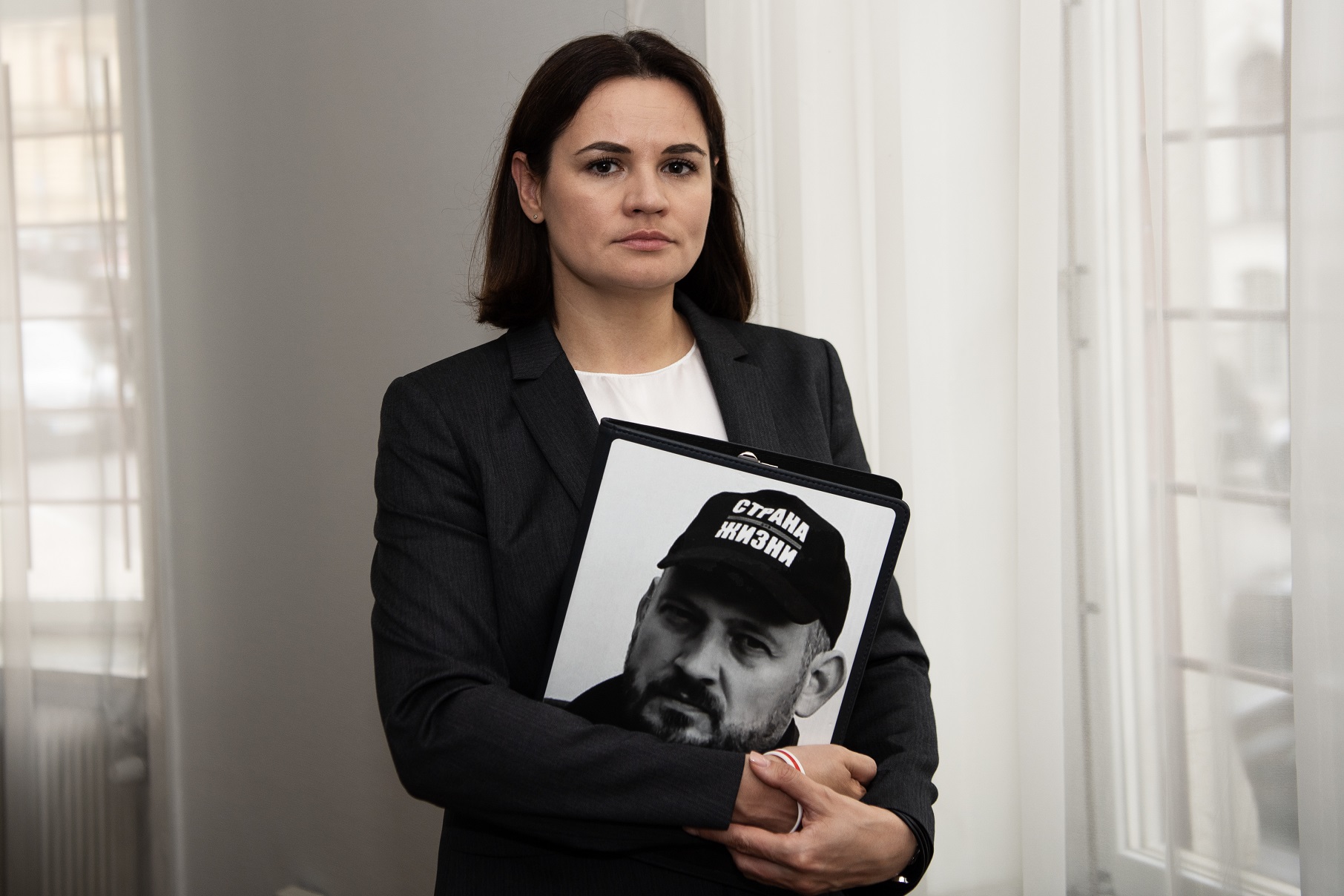 В 2021 году он был приговорен к 18 годам колонии усиленного режима Светлана Тихановская с портретом мужа